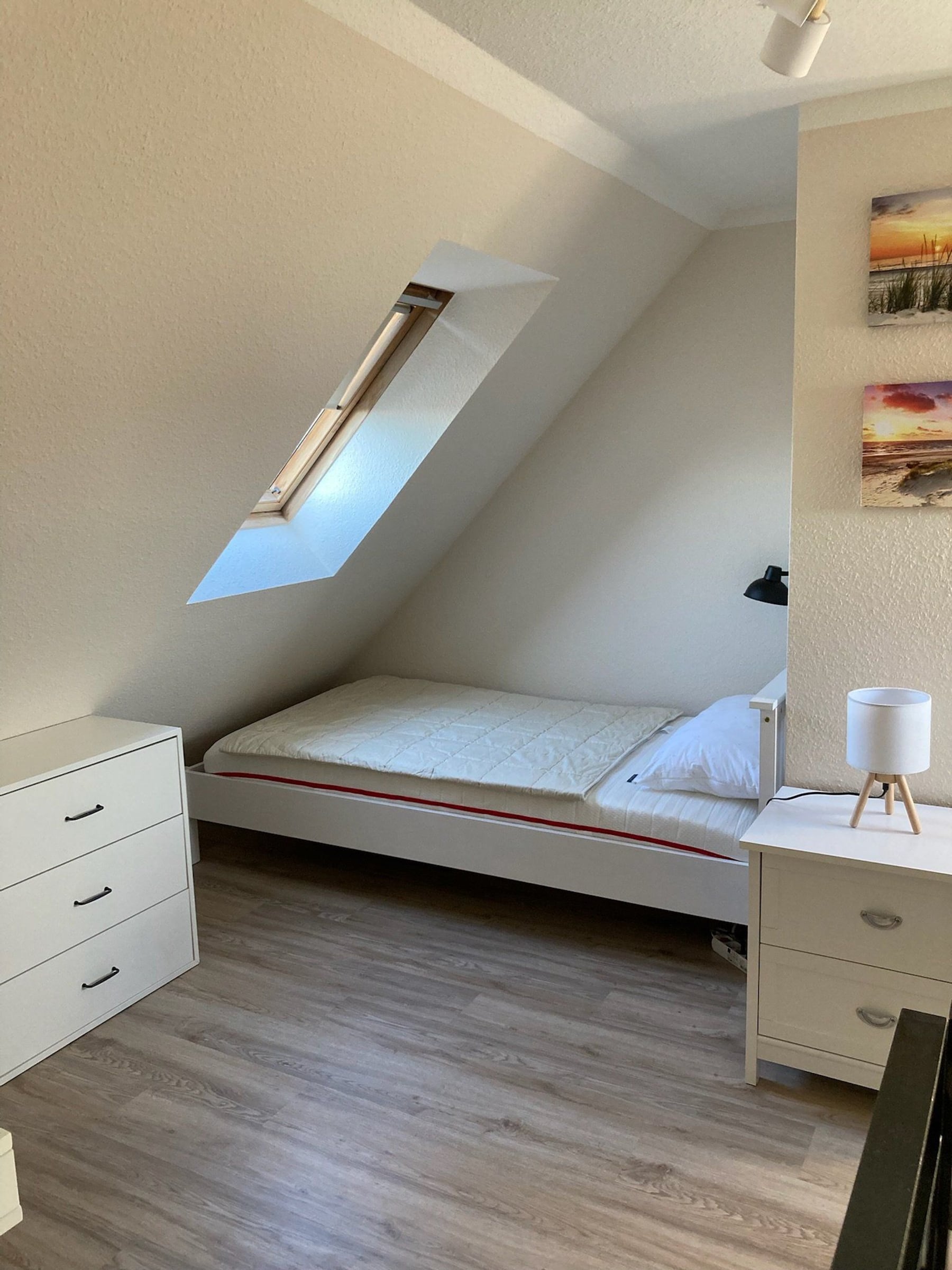 Zimmer mit Einzelbett und Dachschräge nach Renovierung